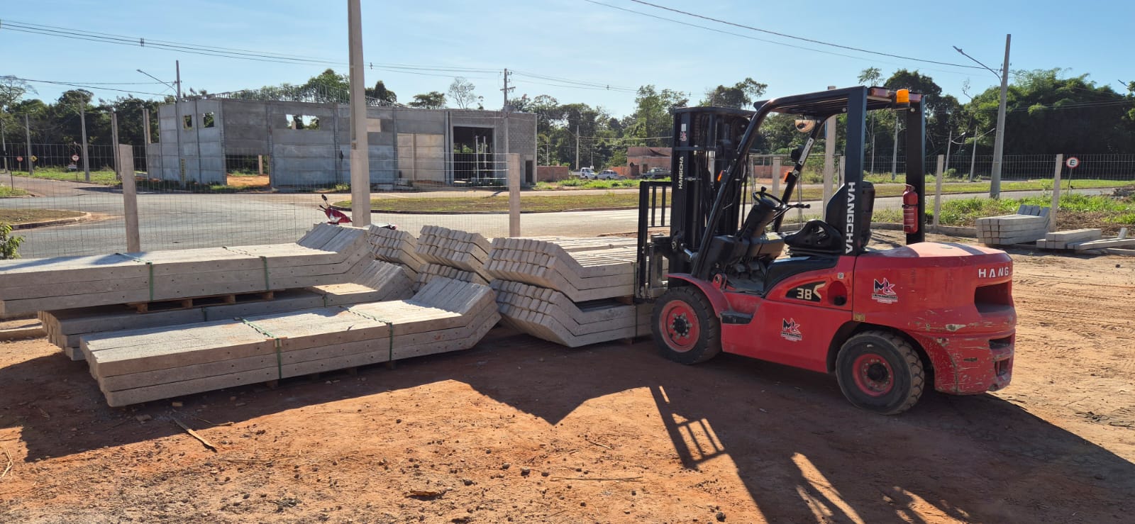 Empilhadeira movimentando mourões de concreto no pátio da fábrica WN Pré-Moldados em Sinop MT